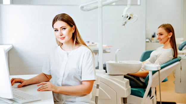 Patient sat on dental chair and women dentist going through the history of patient